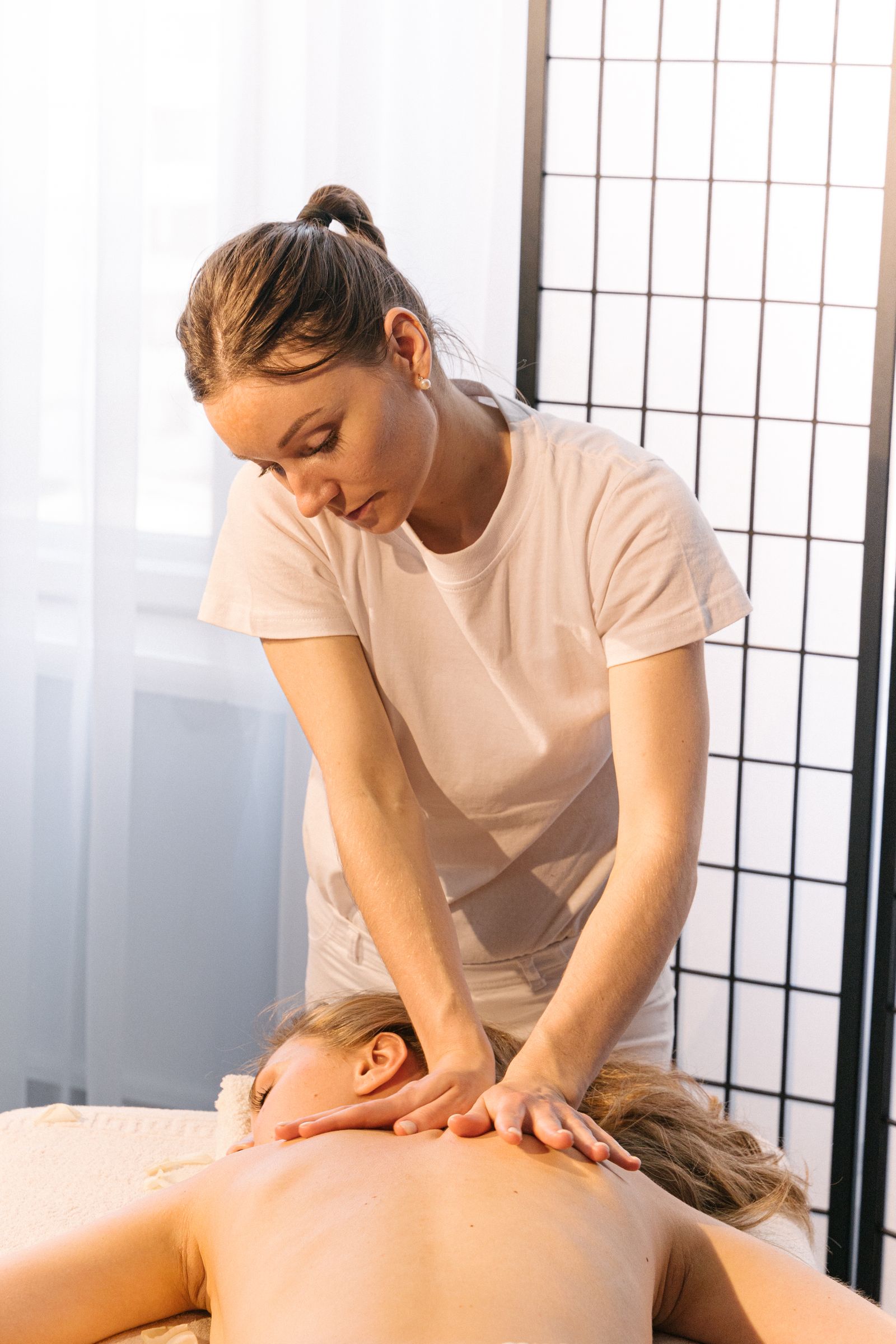 Professional therapist giving a back massage.