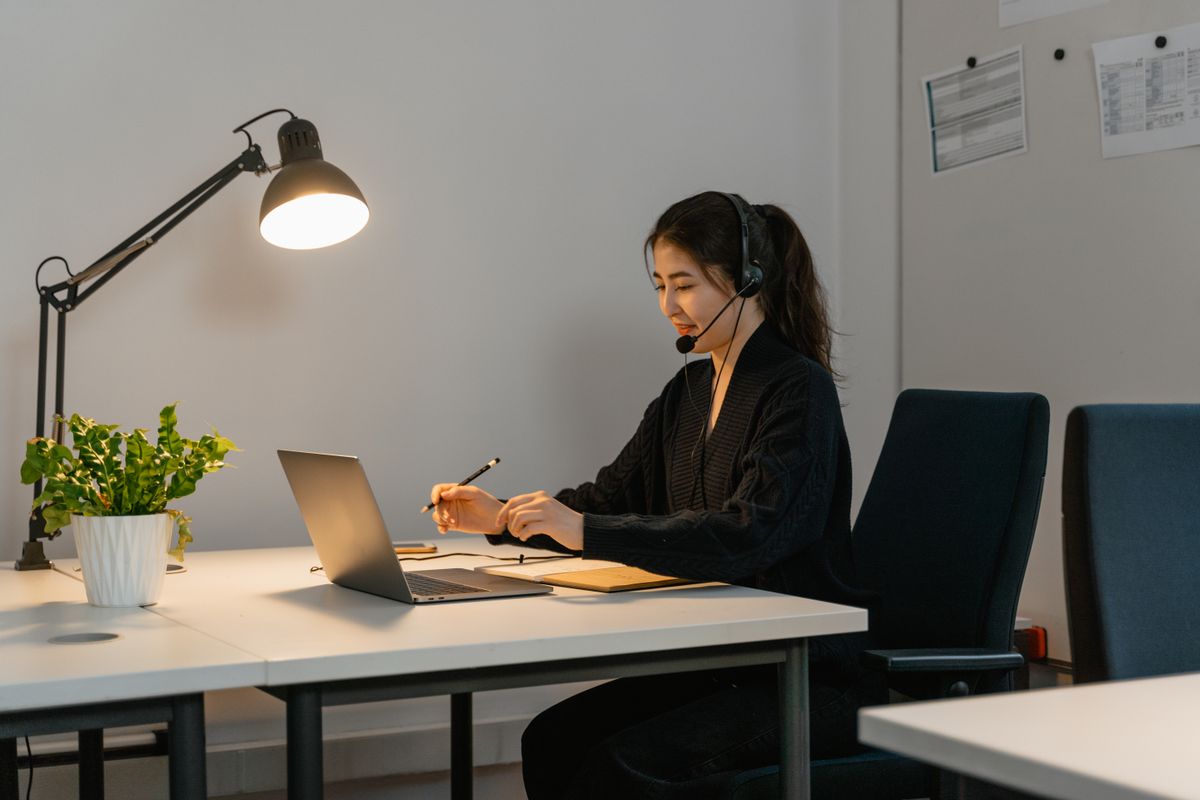 Woman wearing a headset while working at a laptop