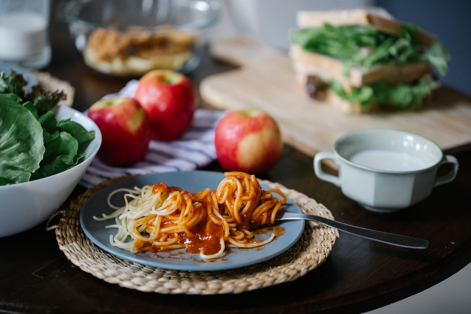 A plate of pasta served with fresh food on a dining table.